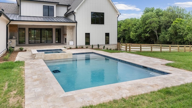 rear view of house with a yard, a patio, a fenced in pool, an in ground hot tub, and a standing seam roof