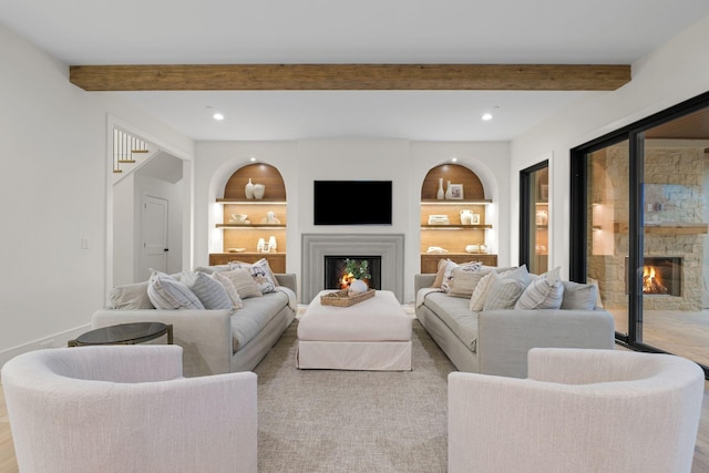 living area with a warm lit fireplace, beamed ceiling, and recessed lighting