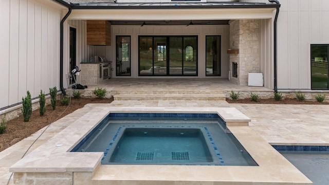 exterior space featuring stone siding, an in ground hot tub, and a patio