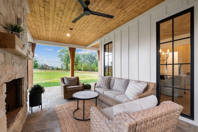 view of patio featuring ceiling fan and an outdoor living space with a fireplace
