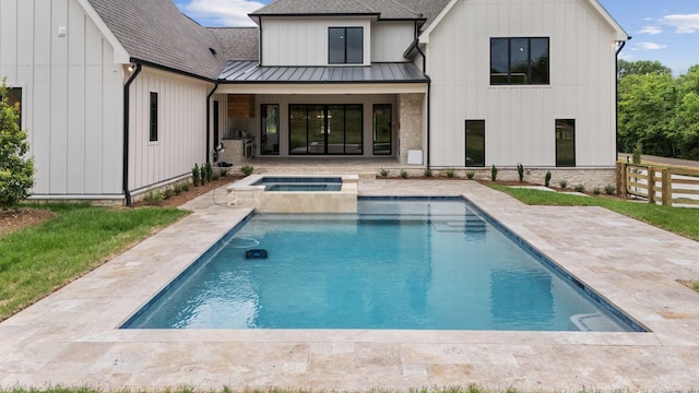 rear view of house featuring fence, a patio, metal roof, a shingled roof, and a standing seam roof