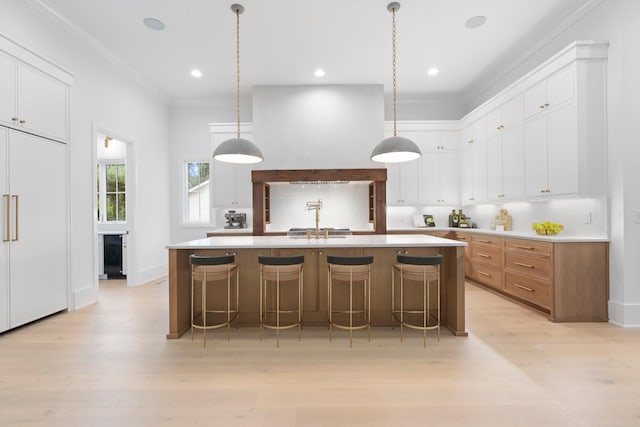 1408 Adams St, Franklin, TN 37064 - kitchen featuring paneled built in refrigerator, light wood finished floors, light countertops, a large island with sink, and a kitchen bar