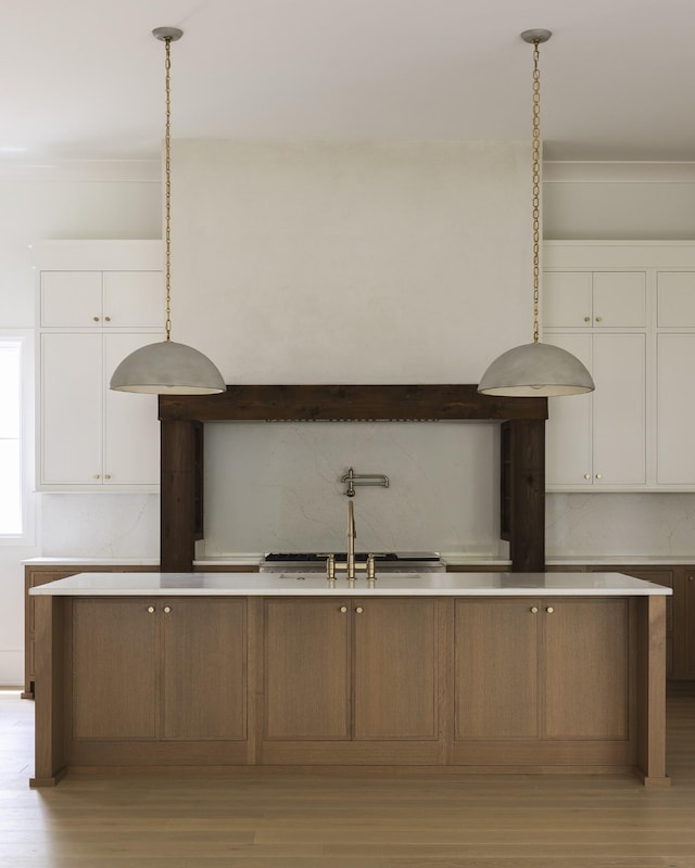 1408 Adams St, Franklin, TN 37064 - kitchen with light wood-style floors, white cabinetry, light countertops, and hanging light fixtures