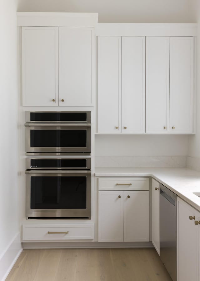 1408 Adams St, Franklin, TN 37064 - kitchen with stainless steel appliances, white cabinetry, light countertops, and light wood-type flooring
