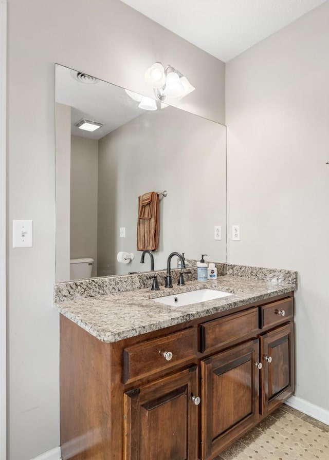 bathroom featuring baseboards, visible vents, vanity, and toilet