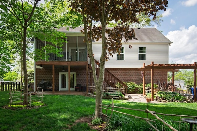 rear view of house featuring a lawn, brick siding, fence, a patio, and a sunroom