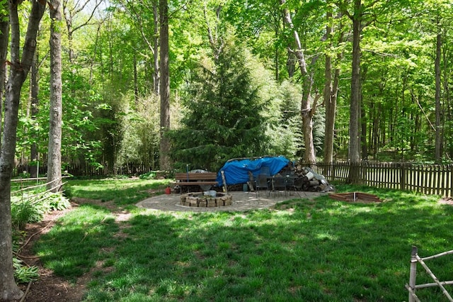 view of yard with a wooded view and fence