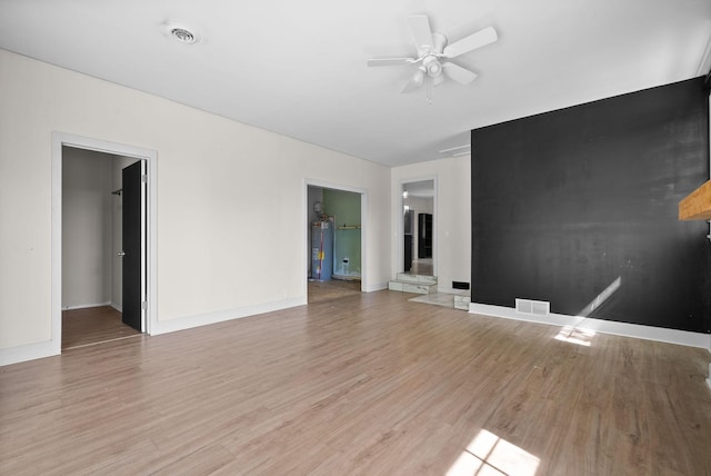 1872 River Rd, Clarksville, TN 37040 - spare room with light wood-style flooring, water heater, a ceiling fan, and baseboards
