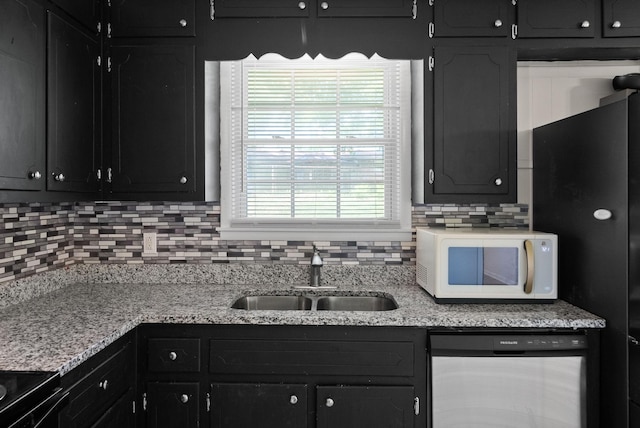 1872 River Rd, Clarksville, TN 37040 - kitchen with white microwave, stainless steel dishwasher, a sink, freestanding refrigerator, and decorative backsplash