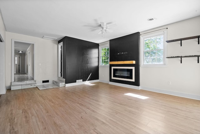 1872 River Rd, Clarksville, TN 37040 - unfurnished living room with light wood-style flooring, a fireplace, a ceiling fan, and baseboards