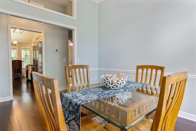 dining area featuring baseboards, an inviting chandelier, and wood-type flooring