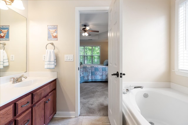 ensuite bathroom featuring ensuite bath, vanity, ceiling fan, and a bath