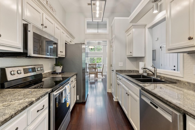 kitchen featuring a sink, white cabinetry, dark wood finished floors, backsplash, and appliances with stainless steel finishes