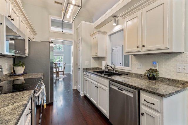 kitchen featuring a sink, baseboards, backsplash, appliances with stainless steel finishes, and dark wood-style floors