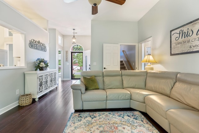 living room featuring baseboards, a ceiling fan, and wood finished floors