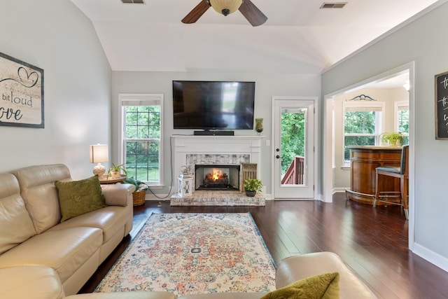 living room featuring lofted ceiling, hardwood / wood-style floors, a fireplace, and ceiling fan