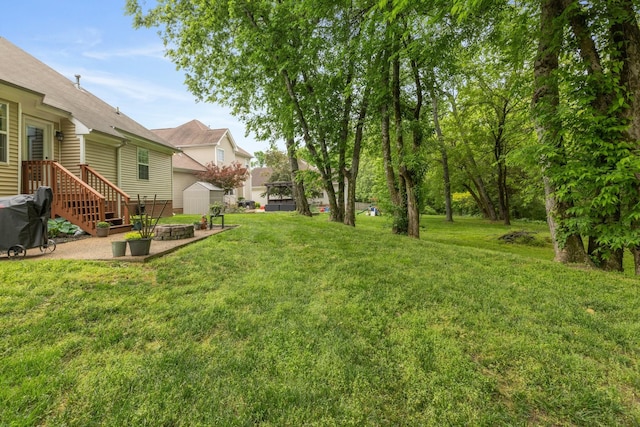 view of yard with an outbuilding, a patio area, and a shed