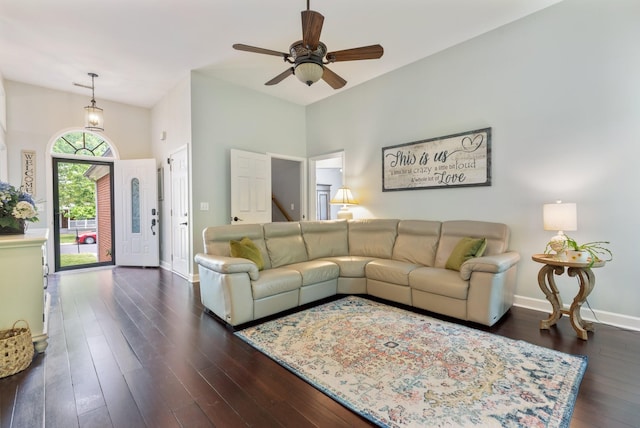 living area featuring ceiling fan, baseboards, and dark wood finished floors