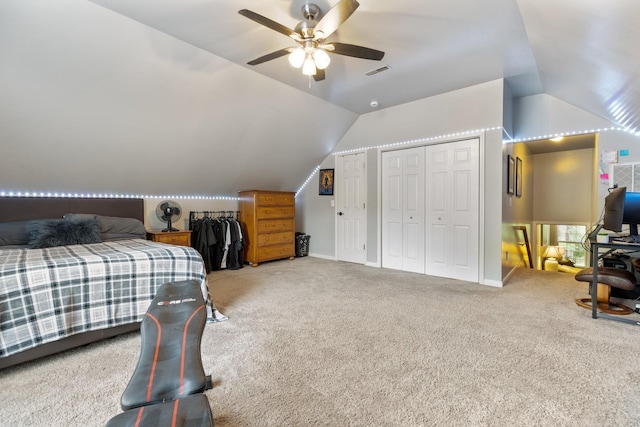 carpeted bedroom with multiple closets, lofted ceiling, a ceiling fan, and visible vents