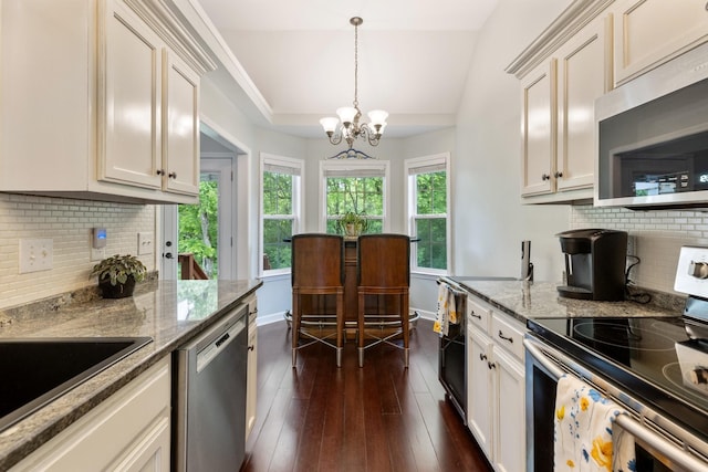 kitchen with dark wood-style flooring, a notable chandelier, appliances with stainless steel finishes, and decorative backsplash