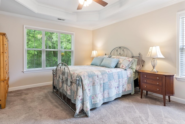 bedroom featuring a tray ceiling, baseboards, carpet flooring, visible vents, and crown molding