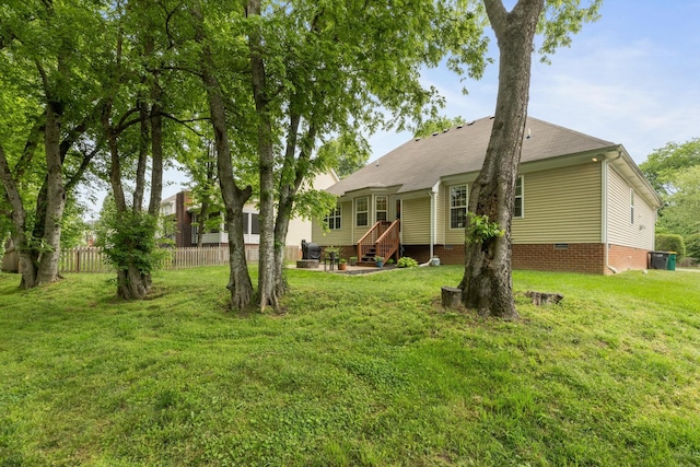 back of house with a yard, roof with shingles, fence, and crawl space