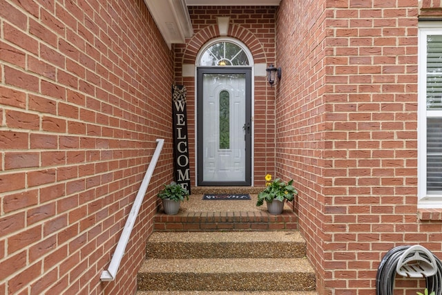 entrance to property featuring brick siding