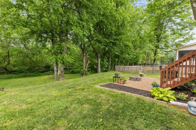 view of yard with a patio area, stairway, a fire pit, and fence