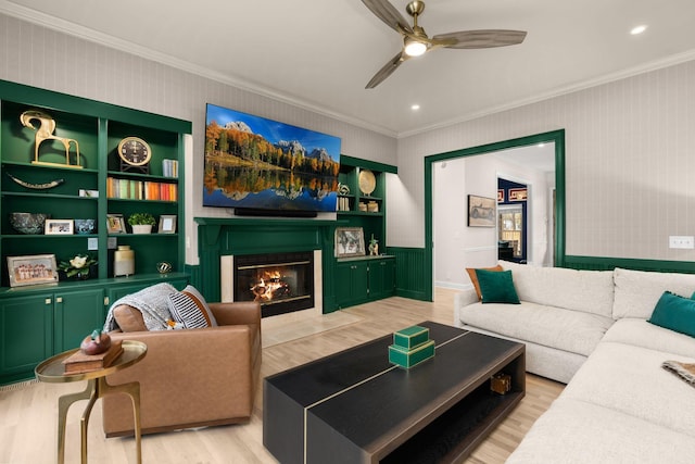living area featuring a fireplace with flush hearth, light wood-type flooring, ceiling fan, ornamental molding, and recessed lighting