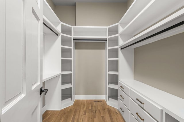 walk in closet featuring visible vents and wood finished floors