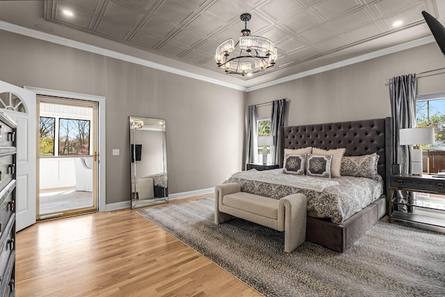 bedroom featuring baseboards, an ornate ceiling, an inviting chandelier, and wood finished floors