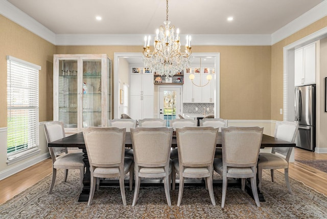 dining area featuring recessed lighting, a notable chandelier, crown molding, and wood finished floors