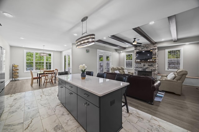 601 Joyce Ave, Lewisburg, TN 37091 - kitchen featuring ceiling fan, a center island, a wealth of natural light, and a stone fireplace