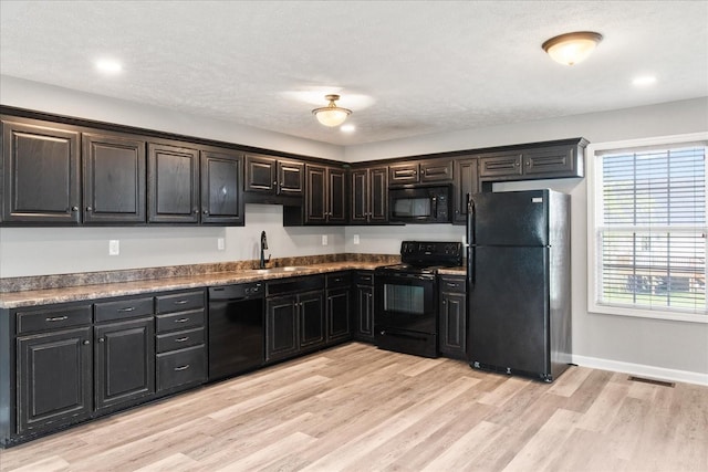 125 Southview Dr, Lewisburg, TN 37091 - kitchen featuring light wood finished floors, a sink, visible vents, baseboards, and black appliances