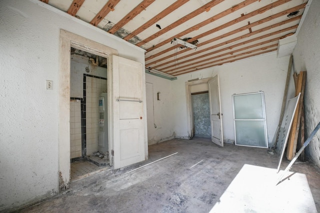 unfurnished bedroom with electric water heater and a garage