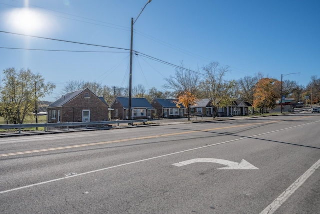 view of road featuring street lights, curbs, and sidewalks