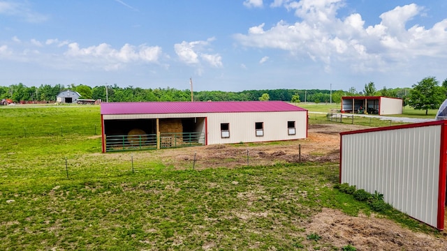 rear view of property with metal roof, an outdoor structure, an outbuilding, and an exterior structure