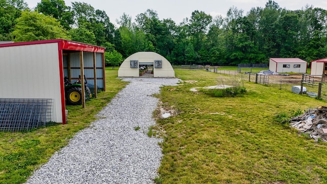 view of yard with an outdoor structure, a pole building, and fence