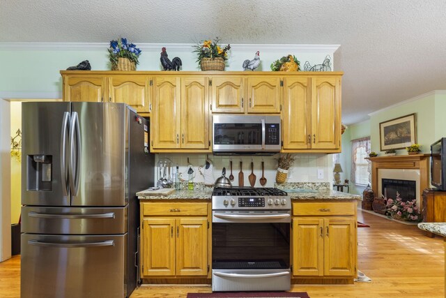 746 Shadow Ln, Belvidere, TN 37306 - kitchen with appliances with stainless steel finishes, a textured ceiling, crown molding, light wood-style floors, and tasteful backsplash