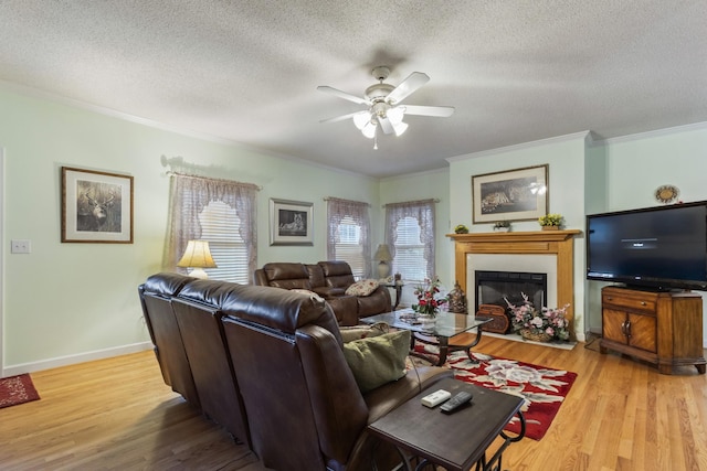 746 Shadow Ln, Belvidere, TN 37306 - living room featuring ornamental molding, a ceiling fan, a glass covered fireplace, light wood-style floors, and a textured ceiling