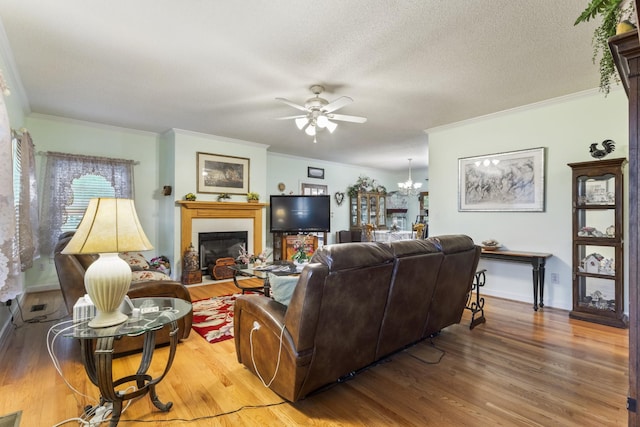 746 Shadow Ln, Belvidere, TN 37306 - living area featuring wood finished floors, a ceiling fan, a glass covered fireplace, crown molding, and a chandelier