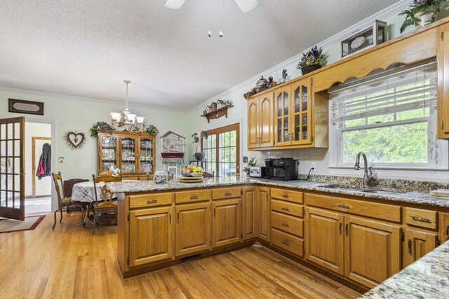 746 Shadow Ln, Belvidere, TN 37306 - kitchen featuring a sink, a peninsula, a textured ceiling, crown molding, and light stone countertops
