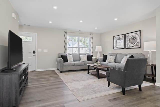 living area with recessed lighting, baseboards, visible vents, and wood finished floors