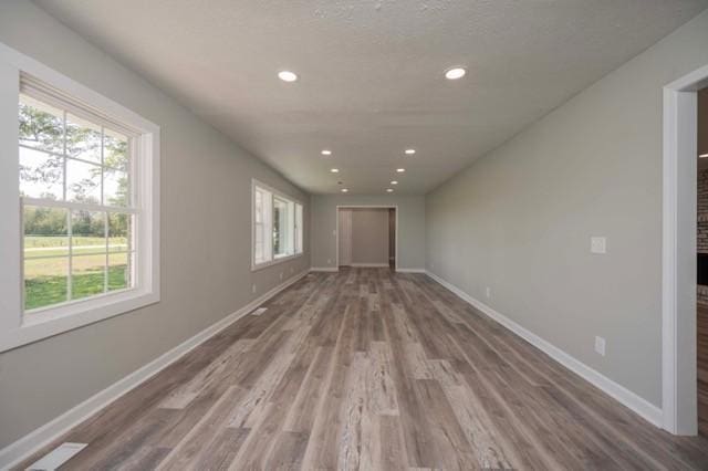 interior space with wood finished floors, baseboards, and recessed lighting