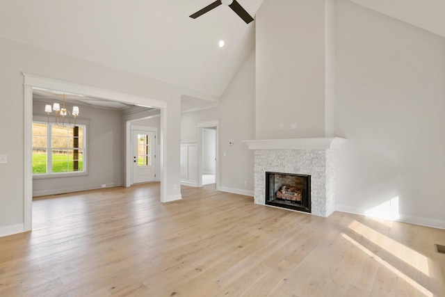 119 Casey St, Brush Creek, TN 38547 - unfurnished living room featuring light wood-style flooring, baseboards, ceiling fan with notable chandelier, high vaulted ceiling, and a fireplace