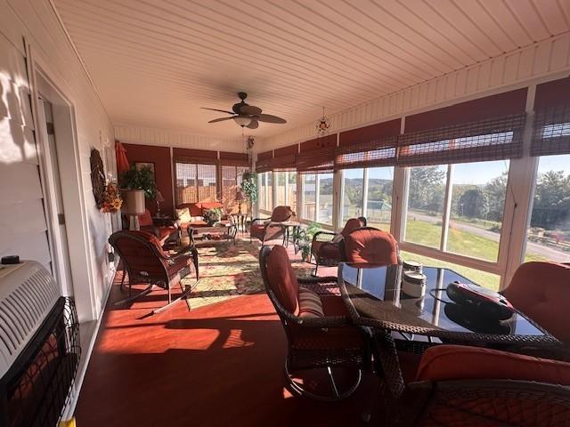 sunroom with a ceiling fan, a wealth of natural light, and heating unit
