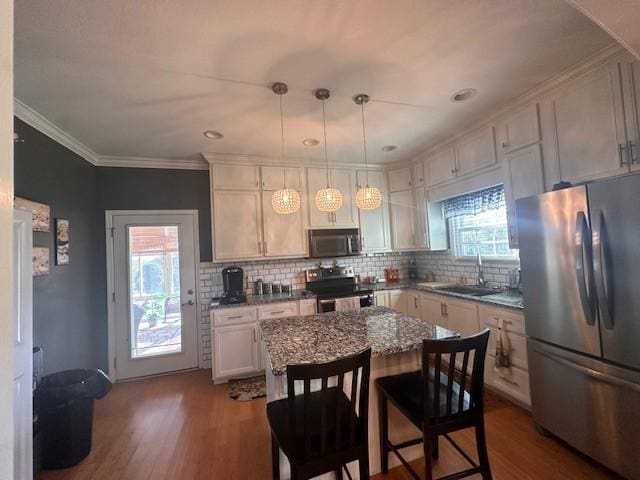 kitchen featuring a sink, dark wood-style flooring, stainless steel appliances, and backsplash