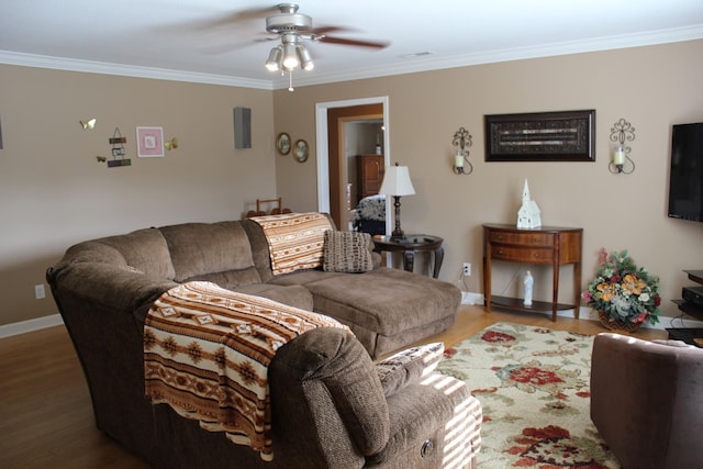 living room with a ceiling fan, ornamental molding, and wood finished floors