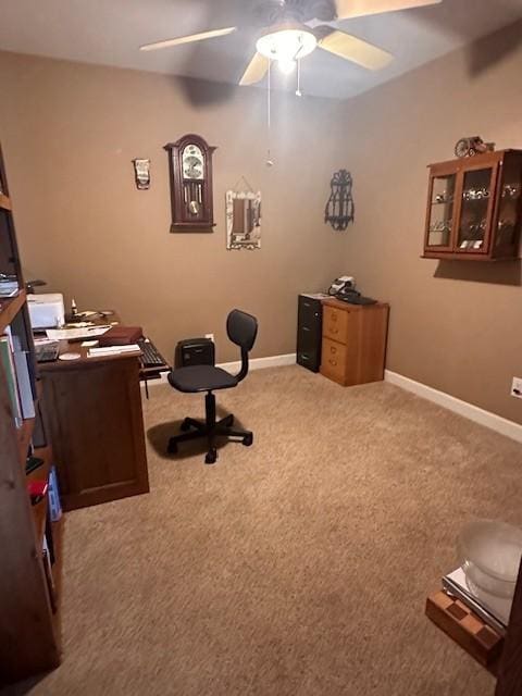 office area with a ceiling fan, baseboards, and carpet