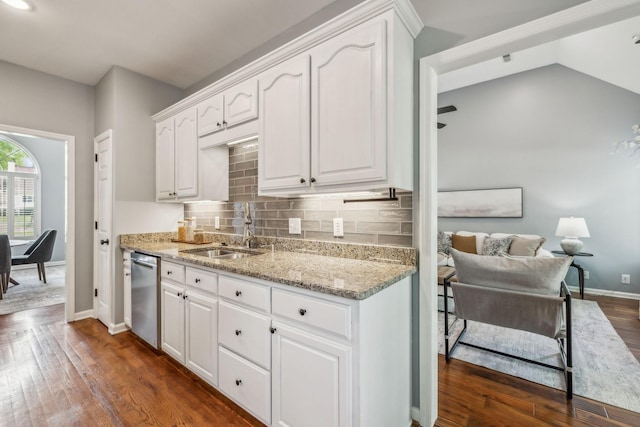 kitchen featuring dishwasher, dark wood-type flooring, light stone counters, and a sink